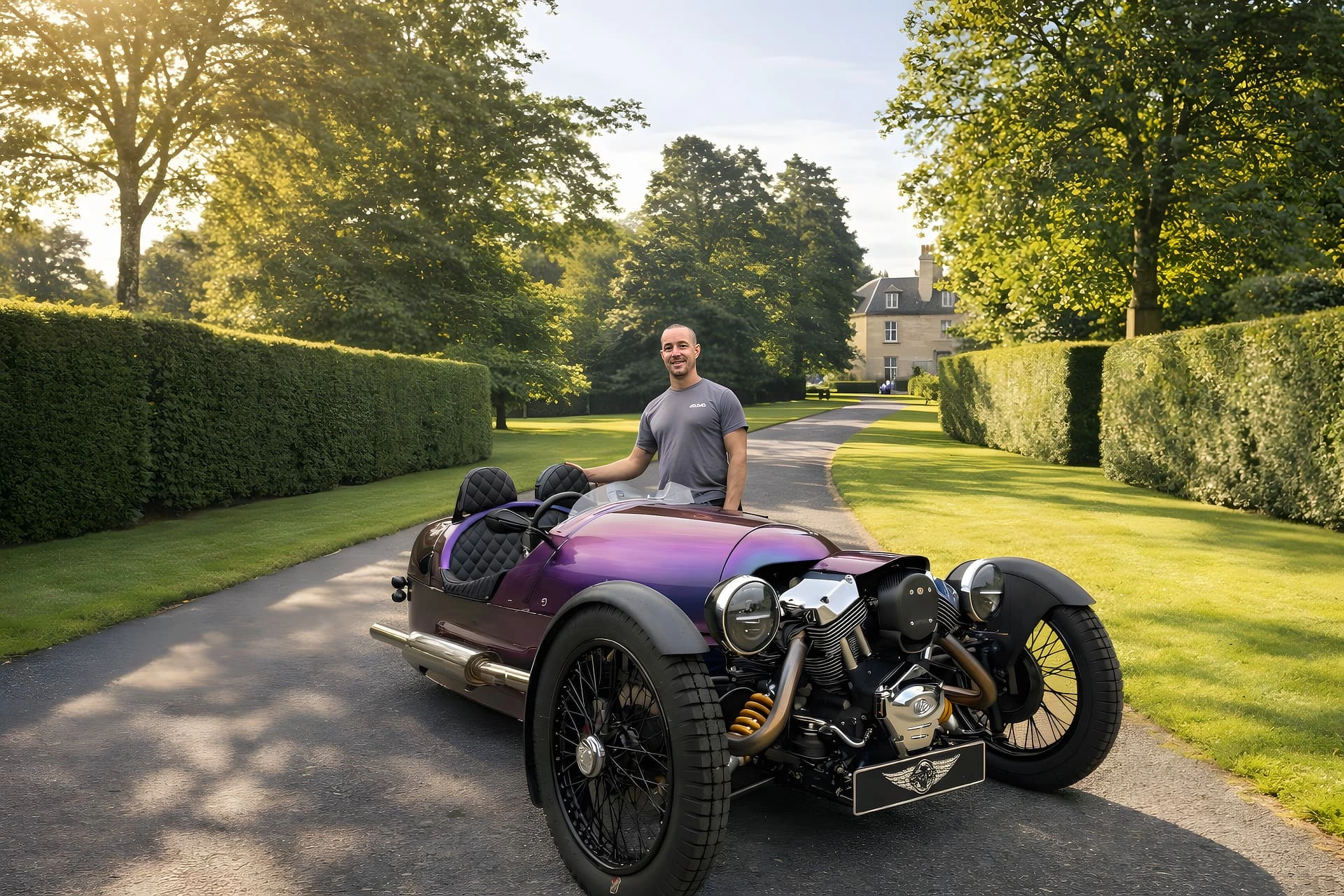 Craig Januszkiewicz, owner of M3W Services UK, standing beside an iridescent purple Morgan 3 Wheeler