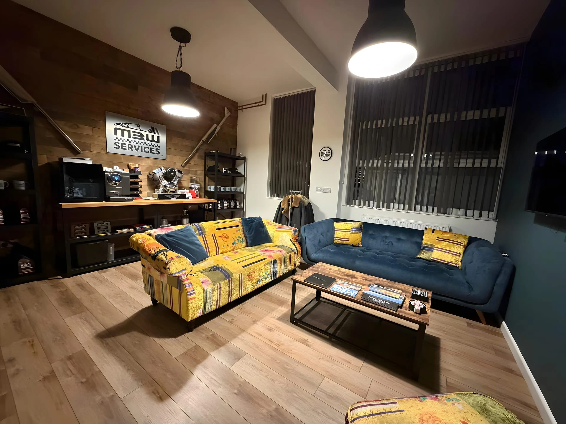 Customer lounge at the M3W Services UK workshop with sofas and merchandise wall