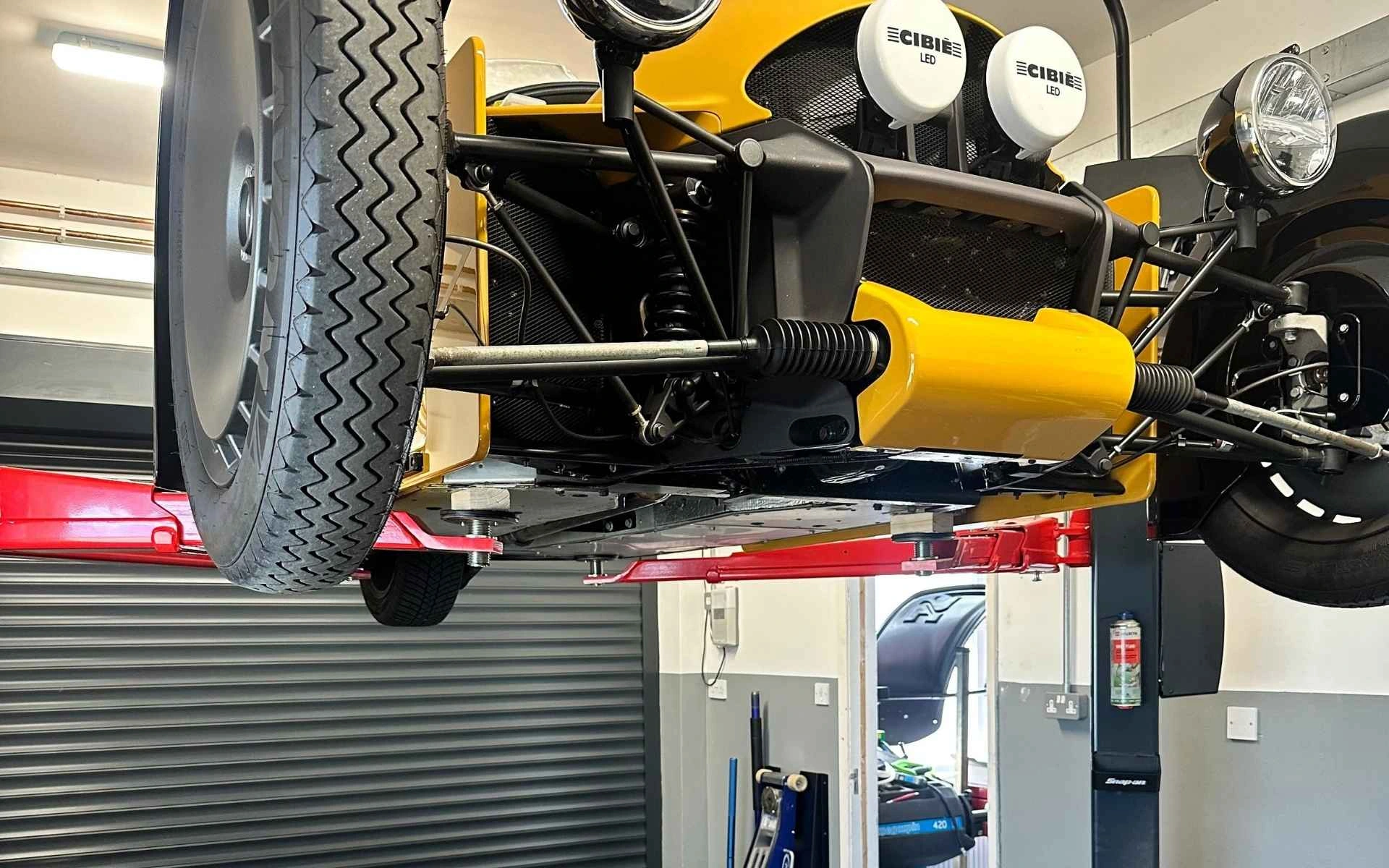 Yellow Morgan Super 3 raised on the lift at M3W Services UK&rsquo;s Purton workshop